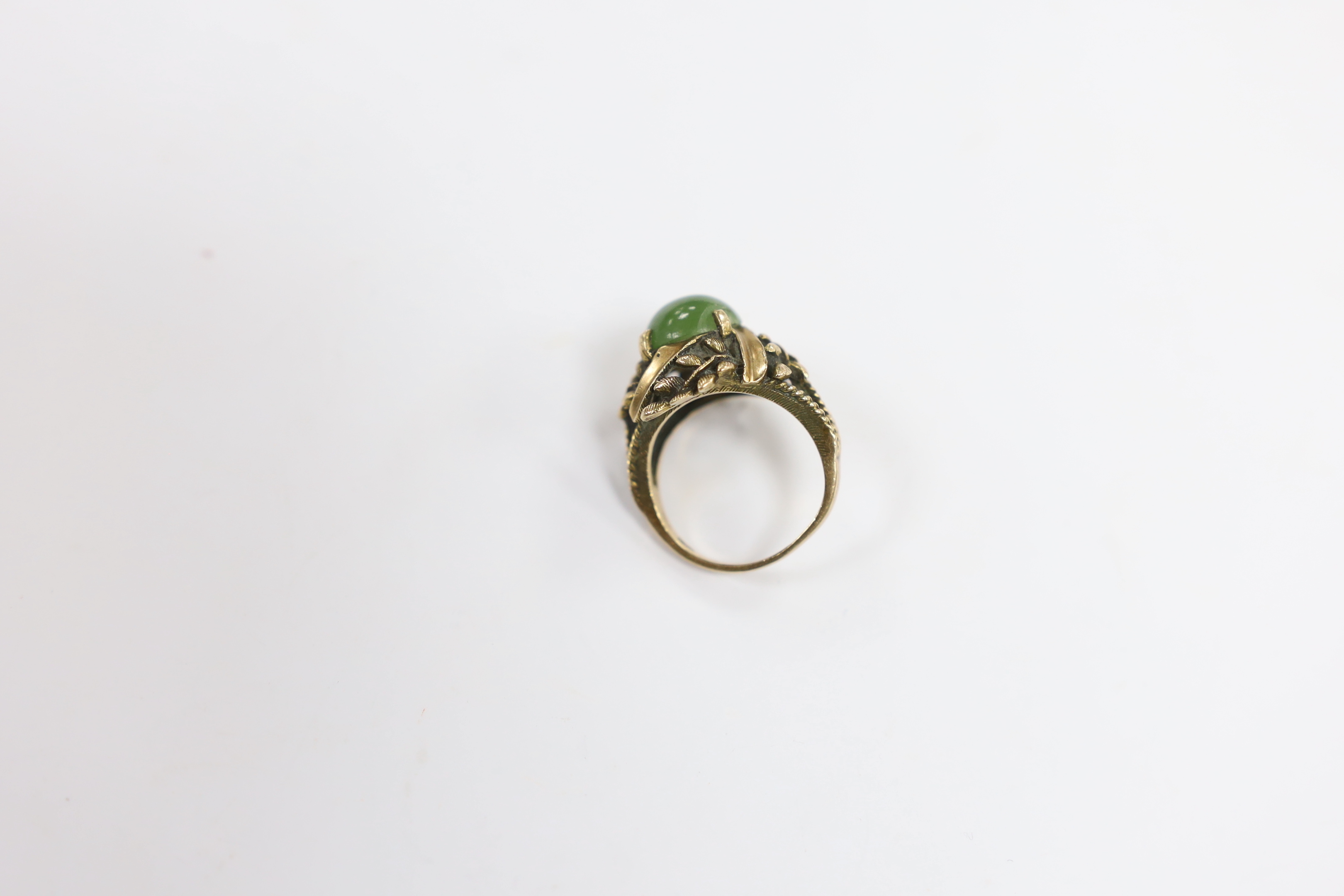 A 10k and oval cabochon jade set dress ring, size L, gross weight 6.2 grams.